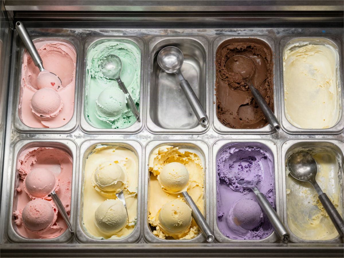 Looking down into the dipping cabinet at ten steel tubs of ice cream.